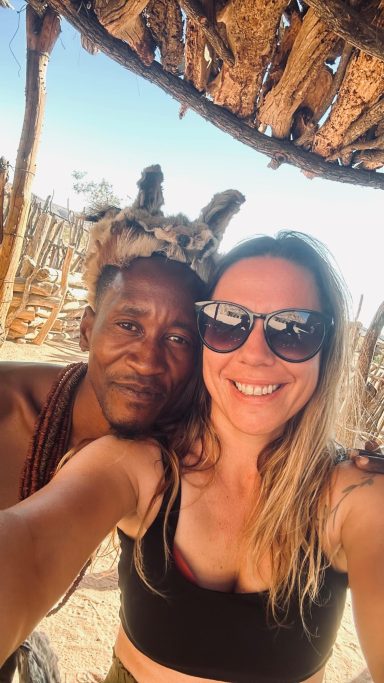 A smiling couple posing together outdoors in a rustic setting.